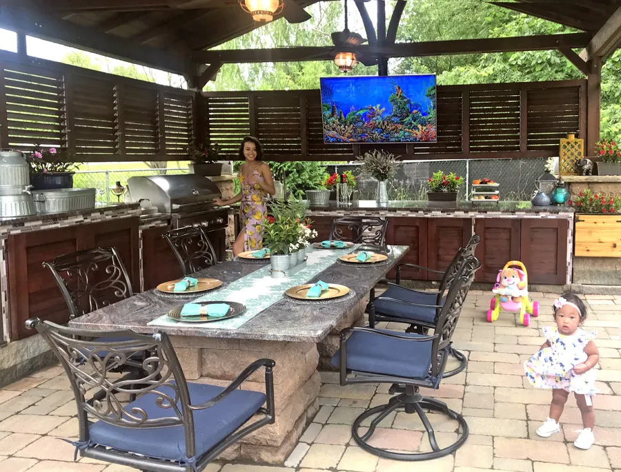 Del Norte Outdoor Kitchen Pavilion (Options: 20' L x 18' W, Mature Redwood, 4-Post Kit for High-Wind, 2 Ceiling Fan Bases, 2 Electrical Wiring Trim Kits, 2 Sets of Louvers on 2 Sides, No Post Decorative Trims, 9' H Posts Wrapped in Stone After Installation, Coffee-Stain Premium Sealant). Photo Courtesy of Shawn and Marilyn Murray of Walden, New York.