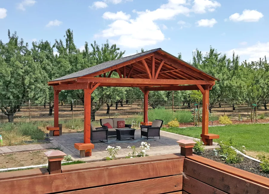 Del Norte Outdoor Kitchen Pavilion (Options: 20' L x 20' W, California Redwood, 4-Post Anchor Kit for Concrete, No Ceiling Fan Bases, No Electrical Wiring Trim Kit, No Post Decorative Trim, Custom Finish [Bare Wood]). Photo Courtesy of D. Greenwood of Escalon, CA.