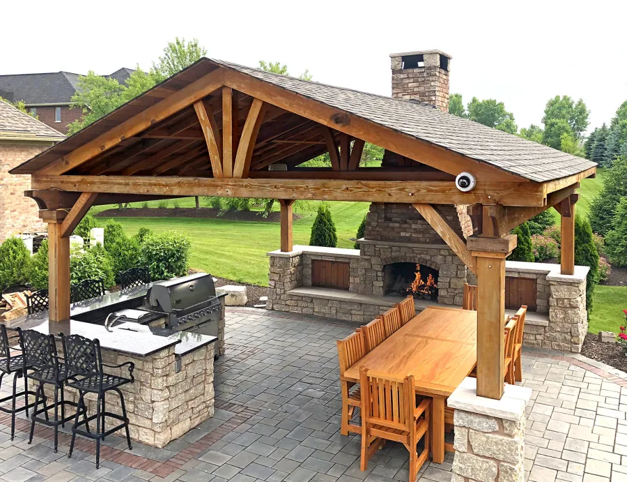 Del Norte Outdoor Kitchen Pavilion (Options: 20' L x 20' W, California Redwood, 4-Post Anchor Kit for High-Wind, 1 Ceiling Fan Base, Transparent Premium Sealant, Custom Cut Out in the Back Overhang to Fit the Fireplace). Photo Courtesy of Tom Mislenkov of Chesterton, Indiana.
