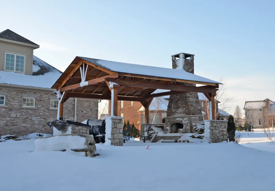 Del Norte Outdoor Kitchen Pavilion (Options: 20' L x 20' W, California Redwood, 4-Post Anchor Kit for High-Wind, 1 Ceiling Fan Base, Transparent Premium Sealant, Custom Cut Out in the Back Overhang to Fit the Fireplace). Photo Courtesy of Tom Mislenkov of Chesterton, Indiana.