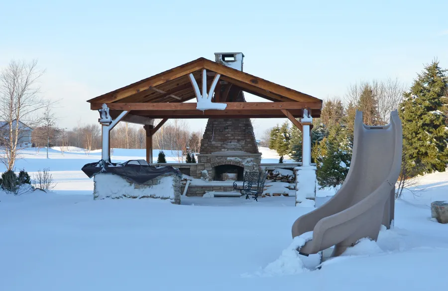 Del Norte Outdoor Kitchen Pavilion (Options: 20' L x 20' W, California Redwood, 4-Post Anchor Kit for High-Wind, 1 Ceiling Fan Base, Transparent Premium Sealant, Custom Cut Out in the Back Overhang to Fit the Fireplace). Photo Courtesy of Tom Mislenkov of Chesterton, Indiana.