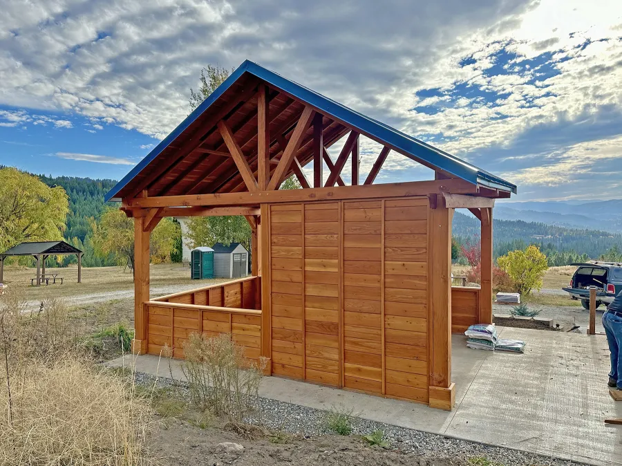 Del Rio Cathedral Ceiling Thick Timber Pavilion (Options: 20' L x 14' W, Privacy Panels on 3 Sides, Douglas-fir, 10' ft Height, No Electrical Wiring Trim, Post Anchor Kit for High-Wind, No Post Decorative Trim, No Ceiling Fan Base, No Curtain Rods, Transparent Premium Sealant). Photo Courtesy of L. Gleim of Malo, WA.