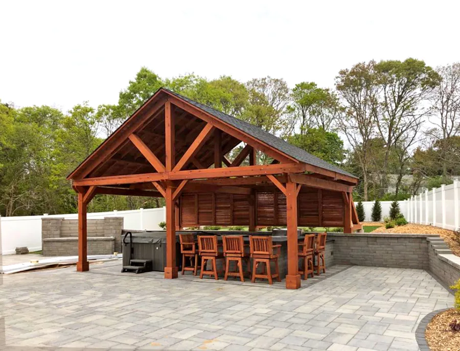 Del Rio Cathedral Ceiling Thick Timber Pavilion  (Options: 18' L x 26' W, California Redwood, 6-Post Anchor Kit for Concrete, Electrical Wiring Trim for 2 Posts, 9.5' Posts, 2 Ceiling Fan Bases, No Privacy Panels, No Curtain Rods, Transparent Premium Sealant, with Extra Knee Braces on the Back by Custom Request). Photo Courtesy of B. Poutre of North Falmouth, Massachusetts.