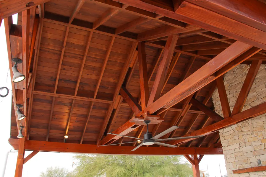 Del Rio Cathedral Ceiling Thick Timber Pavilion (Options: 42' L x 22' Triangle Base W, No Privacy Panels, Mature Redwood, 10' ft Height, Electrical Wiring Trim for 1 Post, 6-Post Anchor Kit for High-Wind, No Post Decorative Trim, 2 Ceiling Fan Bases, No Curtain Rods, Transparent Premium Sealant). Note: Fireplace and kitchen counter was added after the Pavilion was installed by a Mason.  Forever Redwood does not do masonry work, but our designs can incorporate them.