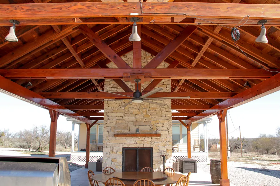 Del Rio Cathedral Ceiling Thick Timber Pavilion (Options: 42' L x 22' Triangle Base W, No Privacy Panels, Mature Redwood, 10' ft Height, Electrical Wiring Trim for 1 Post, 6-Post Anchor Kit for High-Wind, No Post Decorative Trim, 2 Ceiling Fan Bases, No Curtain Rods, Transparent Premium Sealant). Note: Fireplace and kitchen counter was added after the Pavilion was installed by a Mason.  Forever Redwood does not do masonry work, but our designs can incorporate them.