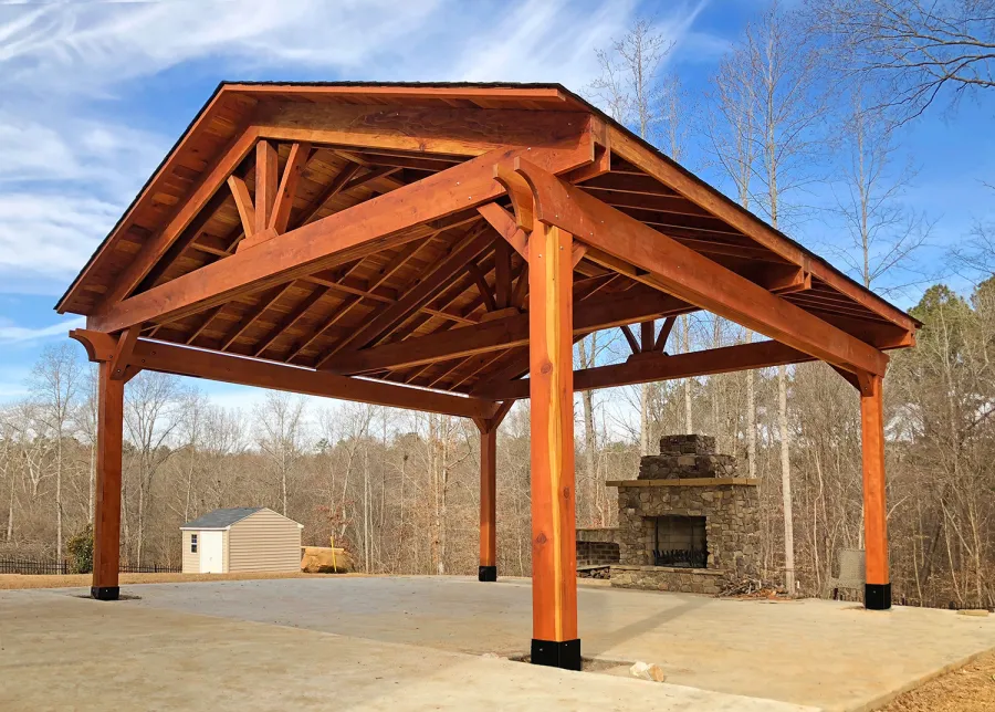 Del Rio Cathedral Ceiling Thick Timber Pavilion (Options: 22' x 22', California Redwood, 4-Post Anchor Kit for High-Wind, With 2 Ceiling Fan Bases, Electrical Wiring Trim Kit for 1 Post, No Post Decorative Trim, Transparent Premium Sealant, 1 1/2" x 11 1/4" Supports and Rafters by Custom Request). Has some customized details. Photo Courtesy of B. Morales of Clayton, NC.