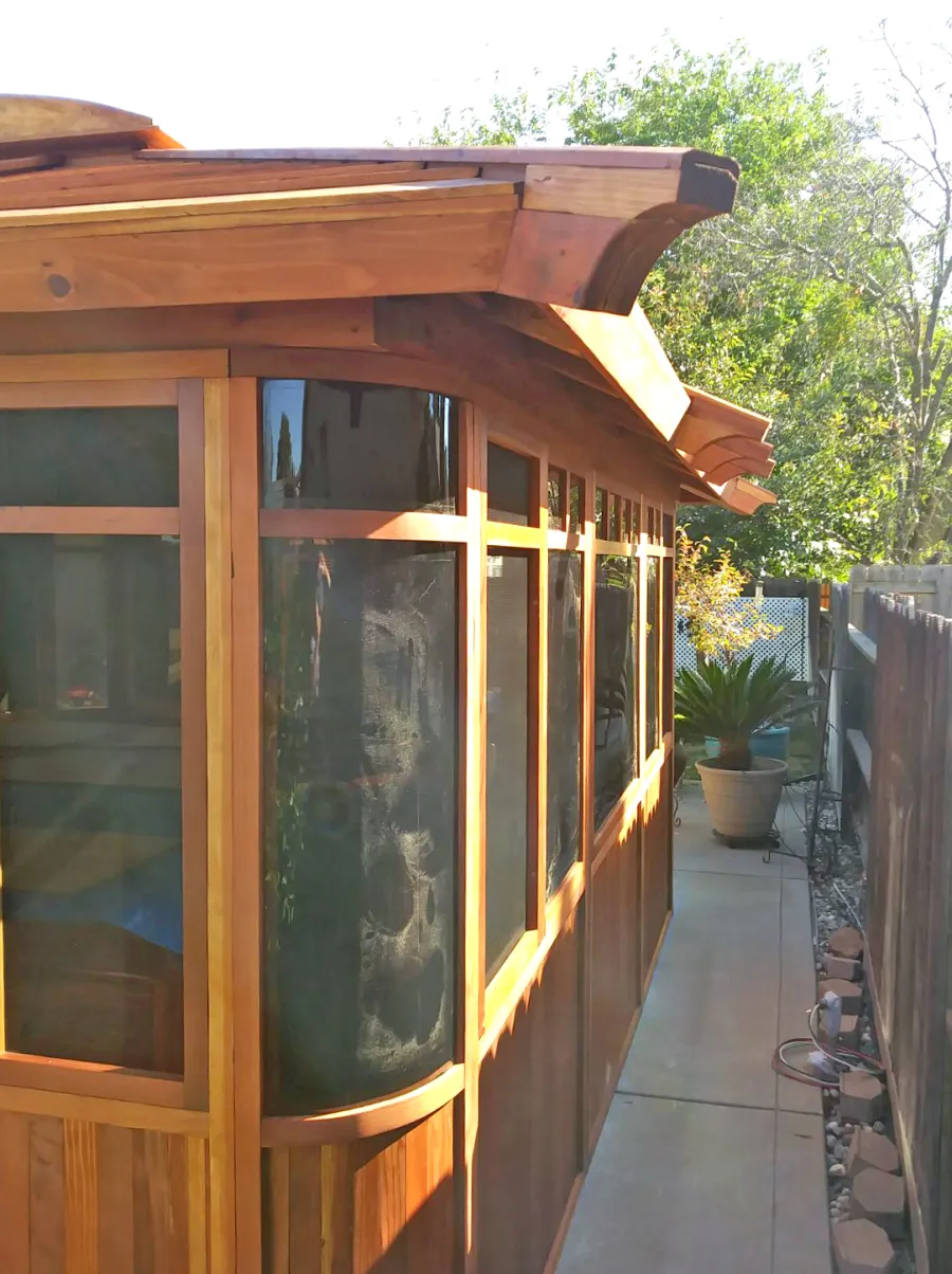 DIY Wood Gazebo (14' L, 12' W, California Redwood, All Sliding Windows with Screens, 4' x 6' Skylight, 36" H Siding Below Windows, Vertical Siding, Japanese Doors with Screens, No Flooring, Transparent Premium Sealant). Photo Courtesy of B. Adkisson of Sacramento, CA. XL Custom Roof per Customer Request.