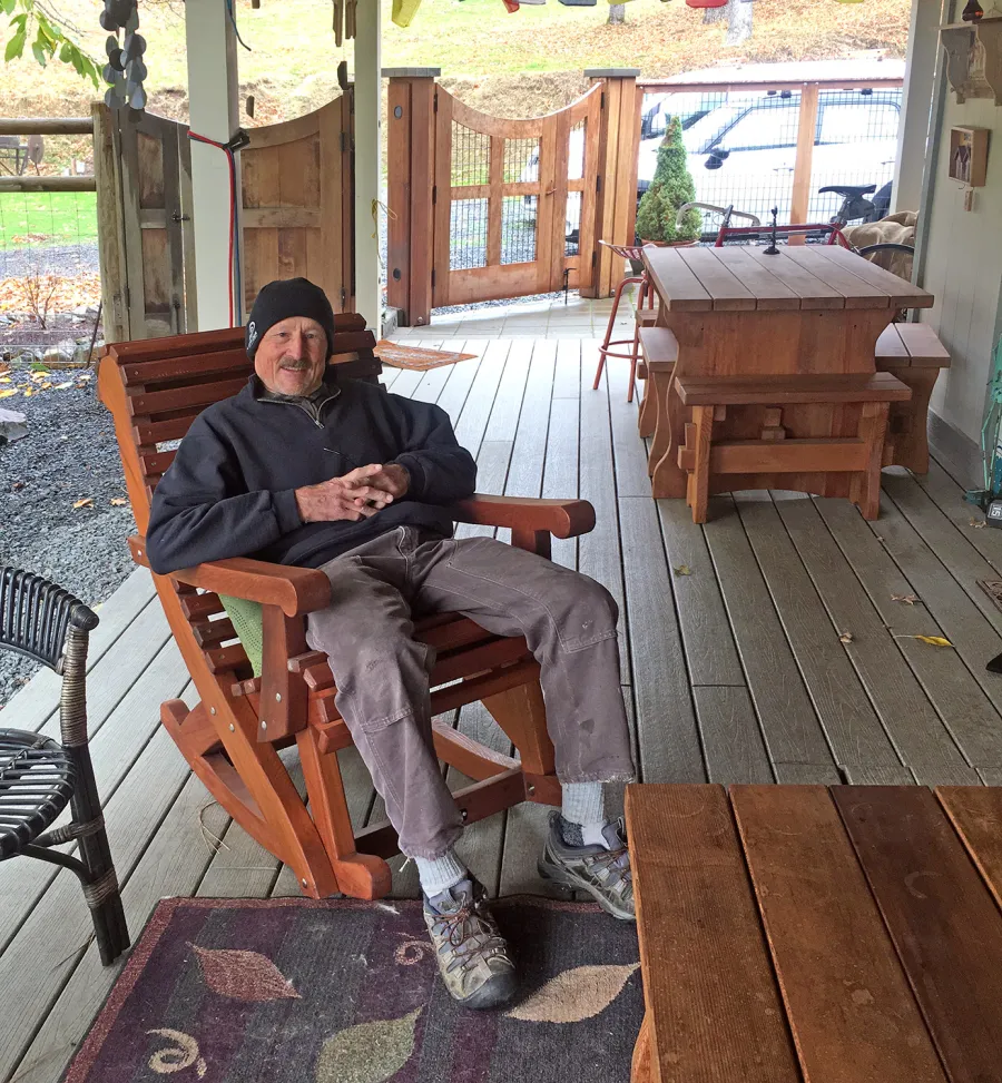 Ensenada Wooden Rocking Chair (Options: Standard Width, Old-Growth Redwood, No Cushion,Transparent Premium Sealant). Photo also shows a Trestle Table Set in background. Photo Courtesy of R. Bogardus of Jacksonville, OR.