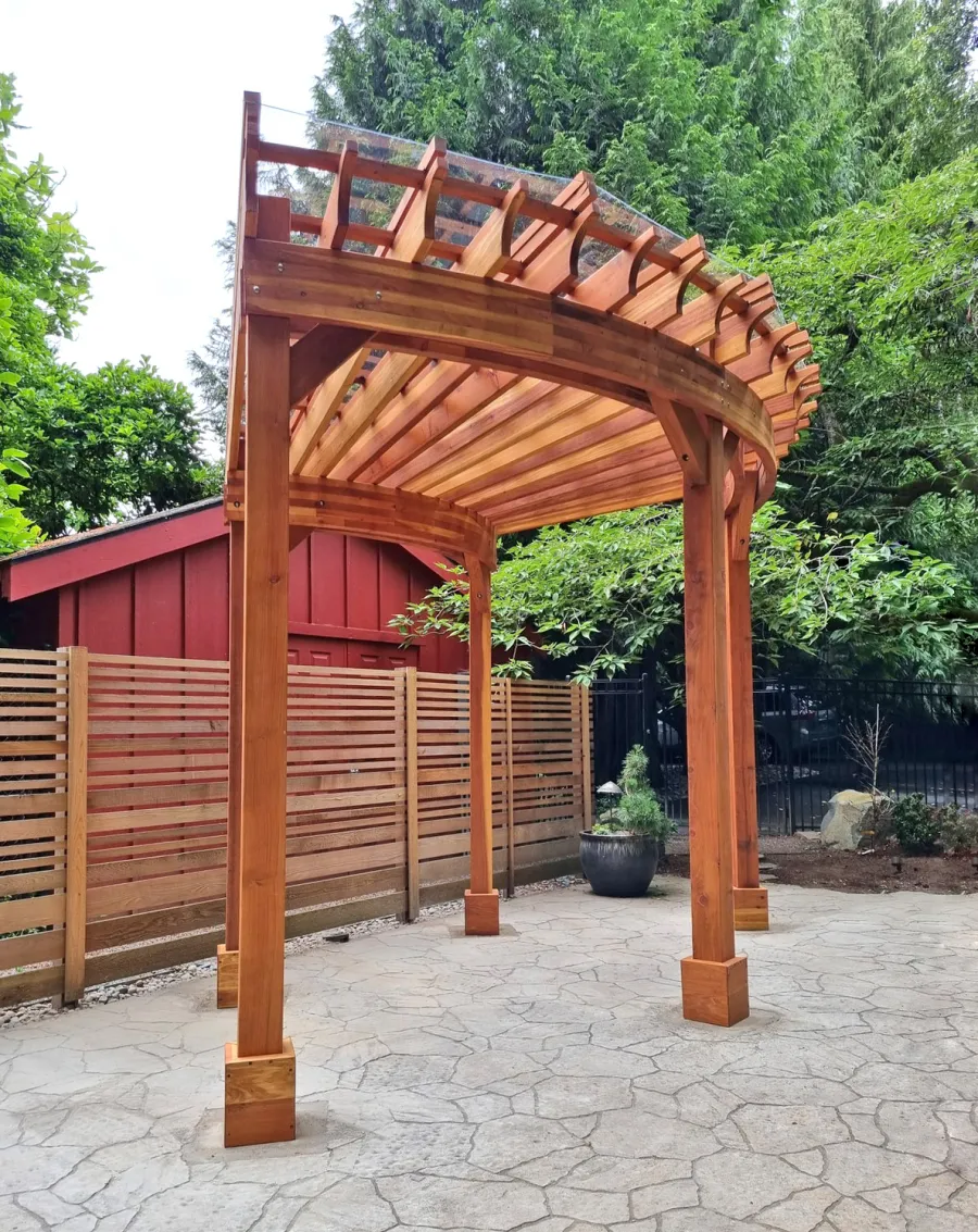 Fan Shaped Pergola Kit (Options: 15' x 18', California Redwood, Open Roof Slats at 12in, With Transparent Rain Guard, Electrical Wiring Trim Kit for 1 Post, Post Anchor Kit for Concrete, No Ceiling Fan Base, 10' Posts, No Curtain Rods, Transparent Premium Sealant). Photo Courtesy of G. Fish of Vancouver, WA.