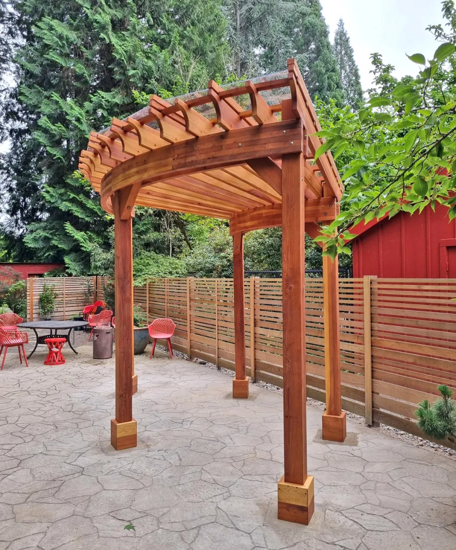 Fan Shaped Pergola Kit (Options: 15' x 18', California Redwood, Open Roof Slats at 12in, With Transparent Rain Guard, Electrical Wiring Trim Kit for 1 Post, Post Anchor Kit for Concrete, No Ceiling Fan Base, 10' Posts, No Curtain Rods, Transparent Premium Sealant). Photo Courtesy of G. Fish of Vancouver, WA.