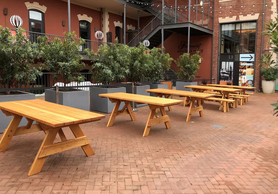 Forever Picnic Tables (Unattached Benches) (Options: 7' L, 34 ½in W, Some Table with No Seating and Some with Side Benches, Douglas-fir,1 Full Length Side Bench Per Side, Standard Tabletop, Slightly Rounded Corners, No Umbrella Hole, Transparent Premium Sealant). Photo also shows some Mendocino and Napa Planters. Photo Courtesy of A. Frost. Installed at Ghirardelli Square, West Plaza Beer Garden, located at 900 North Point Street at the corner of Beach & Larkin Streets, San Francisco, CA.