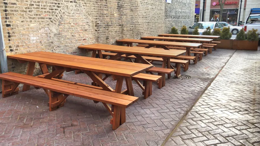 Forever Picnic Tables (Unattached Benches) (Options: 10', 34 ½in W, Side Benches, Mature Redwood, 1 Full Length Side Bench Per Side, Standard Tabletop, Squared Corners, 2in Umbrella Hole, Transparent Premium Sealant). Standard design is with 5 3/4" wide boards. The tabletops in this photo were built for the restaurant by request using bookend construction (where 2 standard width 5 3/4" wide boards are tongue and grooved together to appear as one wider 11 1/2" wide board). If you would like this effect for your tables, just add a note saying want bookend detail added to your order (no extra charge to do this). Photo courtesy of M. Piekarz of Chicago, IL.