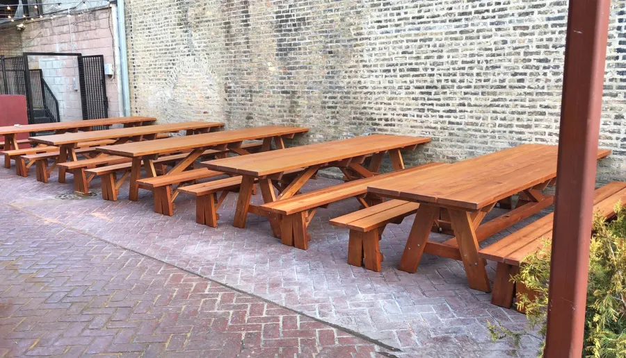 Forever Picnic Tables (Unattached Benches) (Options: 10', 34 ½in W, Side Benches, Mature Redwood, 1 Full Length Side Bench Per Side, Standard Tabletop, Squared Corners, 2" Umbrella Hole, Transparent Premium Sealant). Standard design is with 5 3/4" wide boards. The tabletops in this photo were built for the restaurant by request using bookend construction (where 2 standard width 5 3/4" wide boards are tongue and grooved together to appear as one wider 11 1/2" wide board). If you would like this effect for your tables, just add a note saying want bookend detail added to your order (no extra charge to do this). Photo courtesy of M. Piekarz of Chicago, IL.