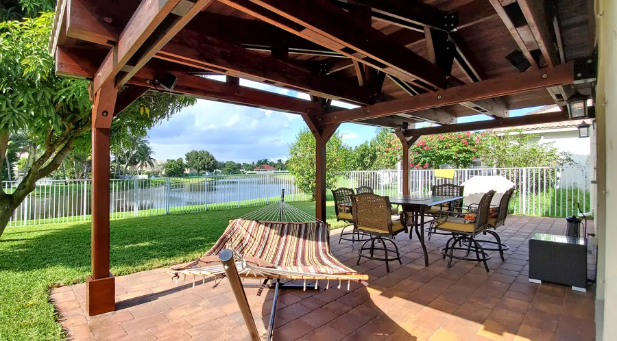 Forever Porch Pavilion (Options: 12' L x 25' W, California Redwood, 3-Post Anchor Kit for High-Wind, No Electrical Wiring Trim, 9ft Posts Height, No Ceiling Fan Base, No Curtain Rods, No Privacy Panels, Transparent Premium Sealant). Photo Courtesy of Carol Varela of Florida.