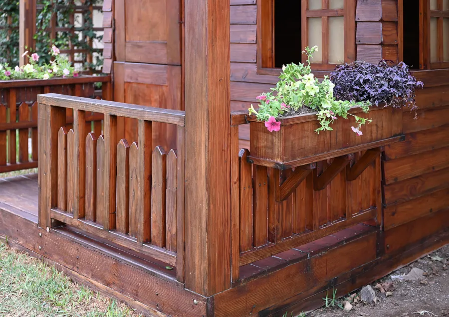 Kid's Backyard Cabin (Options: 12ft L x 8ft W, 7ft Wall H, Douglas-Fir, 4ft Front Porch Size [Included in the Overall Length], Interior Decking, Transparent Premium Sealant). Photo shows structure recently resealed after 6 years of loving service.