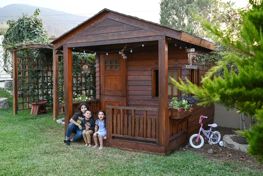 Kid's Backyard Cabin (Options: 12ft L x 8ft W, 7ft Wall H, Douglas-Fir, 4ft Front Porch Size [Included in the Overall Length], Interior Decking, Transparent Premium Sealant). Photo shows structure recently resealed after 6 years of loving service.