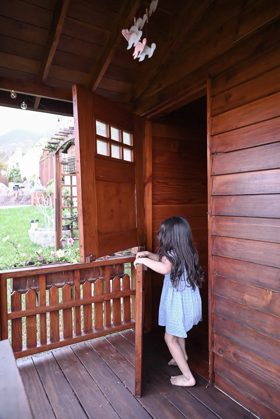 Kid's Backyard Cabin (Options: 12ft L x 8ft W, 7ft Wall H, Douglas-Fir, 4ft Front Porch Size [Included in the Overall Length], Interior Decking, Transparent Premium Sealant). Photo shows structure recently resealed after 6 years of loving service.