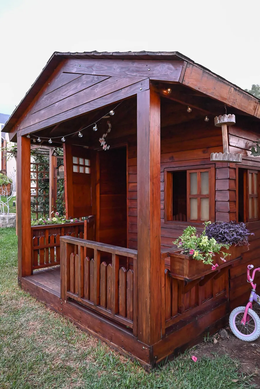 Kid's Backyard Cabin (Options: 12ft L x 8ft W, 7ft Wall H, Douglas-Fir, 4ft Front Porch Size [Included in the Overall Length], Interior Decking, Transparent Premium Sealant). Photo shows structure recently resealed after 6 years of loving service.