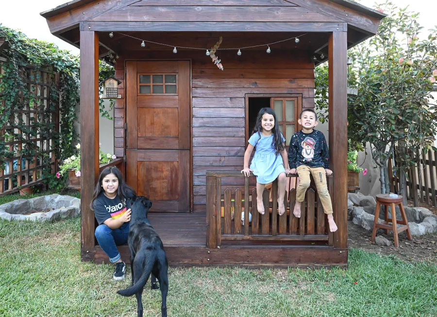 Kid's Backyard Cabin (Options: 12ft L x 8ft W, 7ft Wall H, Douglas-Fir, 4ft Front Porch Size [Included in the Overall Length], Interior Decking, Transparent Premium Sealant). Photo shows structure recently resealed after 6 years of loving service.