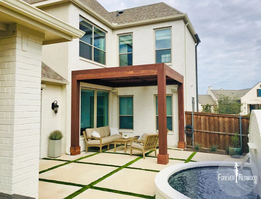 Custom Modern Louvered Garden Pergola (Options: 12' L x 12' W, 10'' x 10'' Posts, Mobile Louvers, California Redwood, 10 ft H, No Electrical Wiring Trim, 3 Post Anchor Kit for Concrete, No post decorative trims, No Ceiling Fan Base, Coffee-Stain Premium Sealant). The Modern Louvered Pergola can be altered to be attached to a building by eliminating one or more posts like this image shows. Photo Courtesy of S. Wottle of Frisco, Texas.