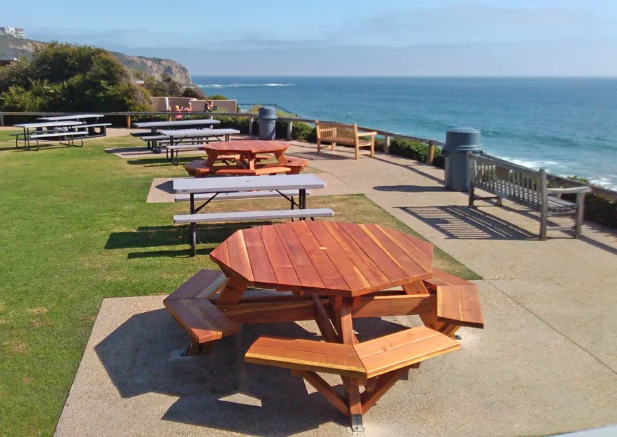 Octagonal Picnic Tables (Options: 5 1/2' Diameter Tabletop, Attached Benches, California Redwood, Standard Tabletop, 1 5/8" Umbrella Hole, Transparent Premium Sealant). Photo Courtesy of G. Cooley of Dana Point, CA. Plastic gray tables not made by Forever Redwood!