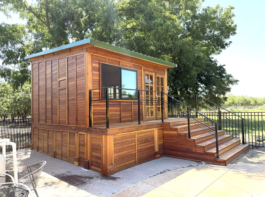 Custom Palo Alto Backyard Cabin (Options: 18' L, 16' W, With 19' x 19' Structural Deck with Steps, California Redwood for Exterior Finished, Douglas-fir Internal Walls and Framing, Double Door, Slidding Windows, Windows Purchased Locally, With Two 2' x 2' Skylights, Metal Roof, Electrical Wire Trim on the Walls, Transparent Premium Sealant). Photo Courtesy of R. and M. Hegwood of Ceres, CA.