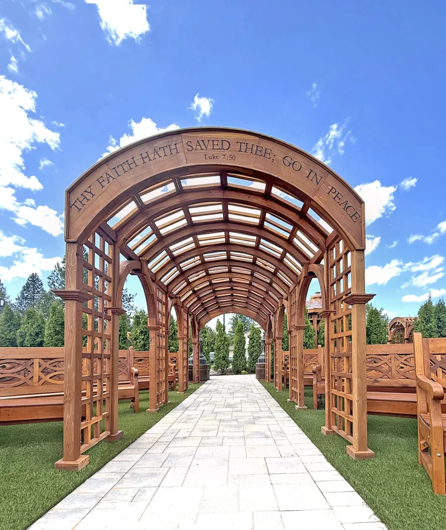 Victorian Trellis (Options: 22' x 8', California Redwood, Custom Engraving, Transparent Premium Sealant). Photo Also Shows Several Hennell Garden Benches. Trellis Installed in Faith Walk Community Fitness Park in Coeur d'Alene, Idaho.