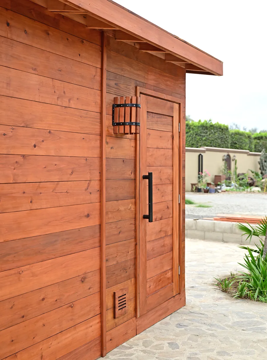 Raul’s Rad Redwood Sauna (Options: 11' W, 8' D, 11' H, California Redwood (for Interiors) & Mature Redwood (for Exteriors), Pitch Roof for Exterior Areas, "L" Shape Bench (2 levels), Transparent Premium Sealant).