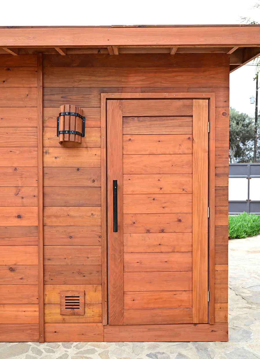 Raul’s Rad Redwood Sauna (Options: 11' W, 8' D, 11' H, California Redwood (for Interiors) & Mature Redwood (for Exteriors), Pitch Roof for Exterior Areas, "L" Shape Bench (2 levels), Transparent Premium Sealant).