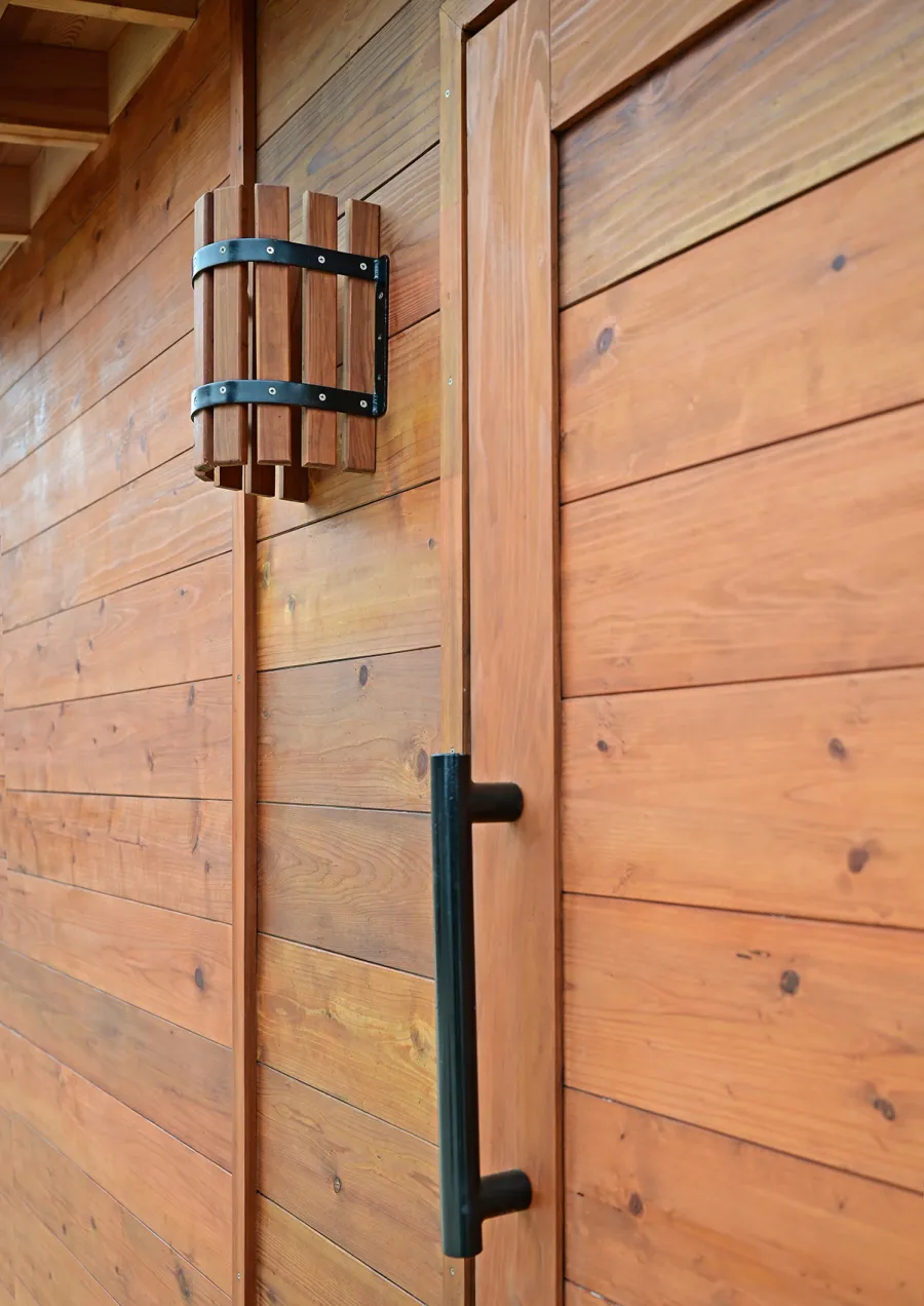 Raul’s Rad Redwood Sauna (Options: 11' W, 8' D, 11' H, California Redwood (for Interiors) & Mature Redwood (for Exteriors), Pitch Roof for Exterior Areas, "L" Shape Bench (2 levels), Transparent Premium Sealant).