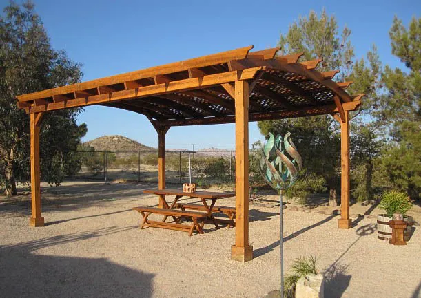 Rectangular Folding Picnic Table below Arched Pergola (Options: 72" L, 24" W, Folding Side Benches, Old-Growth Redwood, 1 Full Length Bench/Side, Standard Tabletop, Checkerboard Design, Slightly Rounded Corners, Umbrella Hole & Plug (1 5/8"), Transparent Premium Sealant). Photo Courtesy of Christine Kelley of Twentynine Palms.