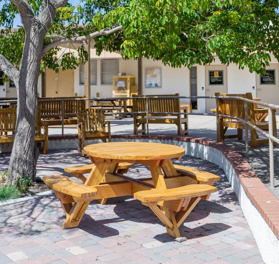 Round Wooden Picnic Table (Attached Benches) (Options: 4' Diameter, Attached Benches, Mosaic Douglas-Fir, Standard Tabletop, No Lazy Susan, No Umbrella Hole, Transparent Premium Sealant). Photo courtesy of Vanguard University [55 Fair Dr, Costa Mesa, CA].