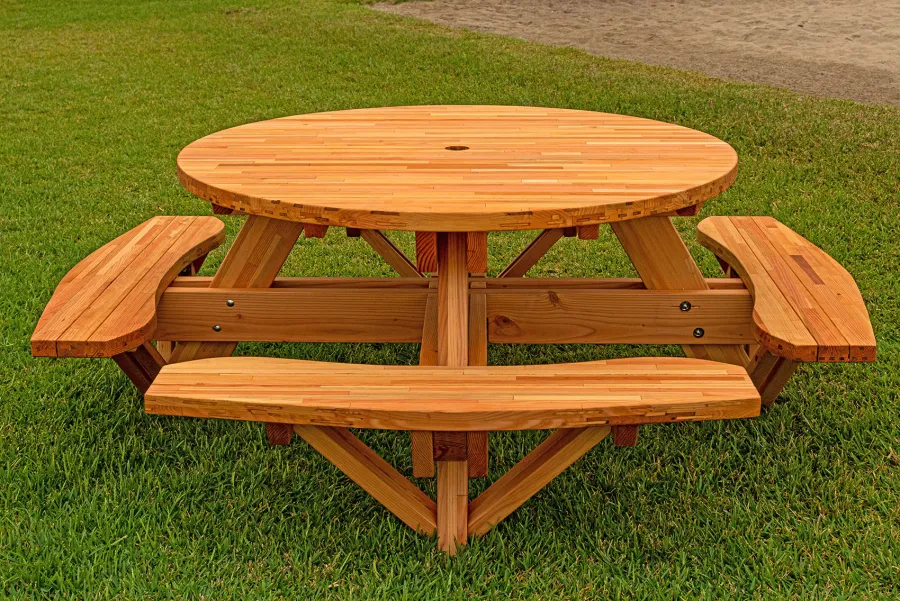 Round Wooden Picnic Table (Attached Benches) (Options: 5' Diameter, Attached Benches, Mosaic Douglas-Fir, Standard Tabletop, No Lazy Susan, 2" Umbrella Hole, Transparent Premium Sealant). Photo courtesy of El Estero Beach Resort in Ensenada, Mexico.