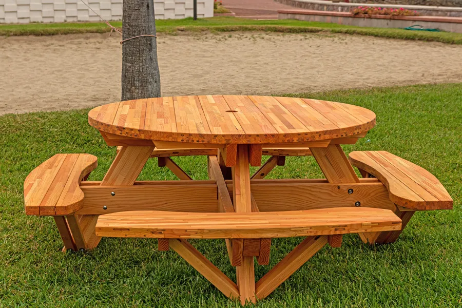 Round Wooden Picnic Table (Attached Benches) (Options: 5' Diameter, Attached Benches, Mosaic Douglas-Fir, Standard Tabletop, No Lazy Susan, 2" Umbrella Hole, Transparent Premium Sealant). Photo courtesy of El Estero Beach Resort in Ensenada, Mexico.