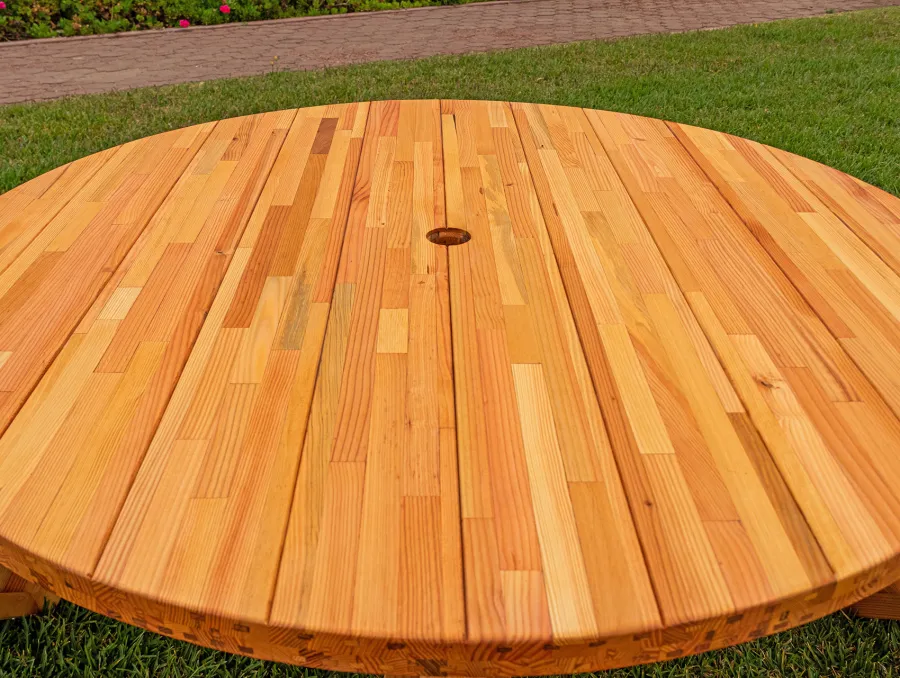 Round Wooden Picnic Table (Attached Benches) (Options: 5' Diameter, Attached Benches, Mosaic Douglas-Fir, Standard Tabletop, No Lazy Susan, 2" Umbrella Hole, Transparent Premium Sealant). Photo courtesy of El Estero Beach Resort in Ensenada, Mexico.