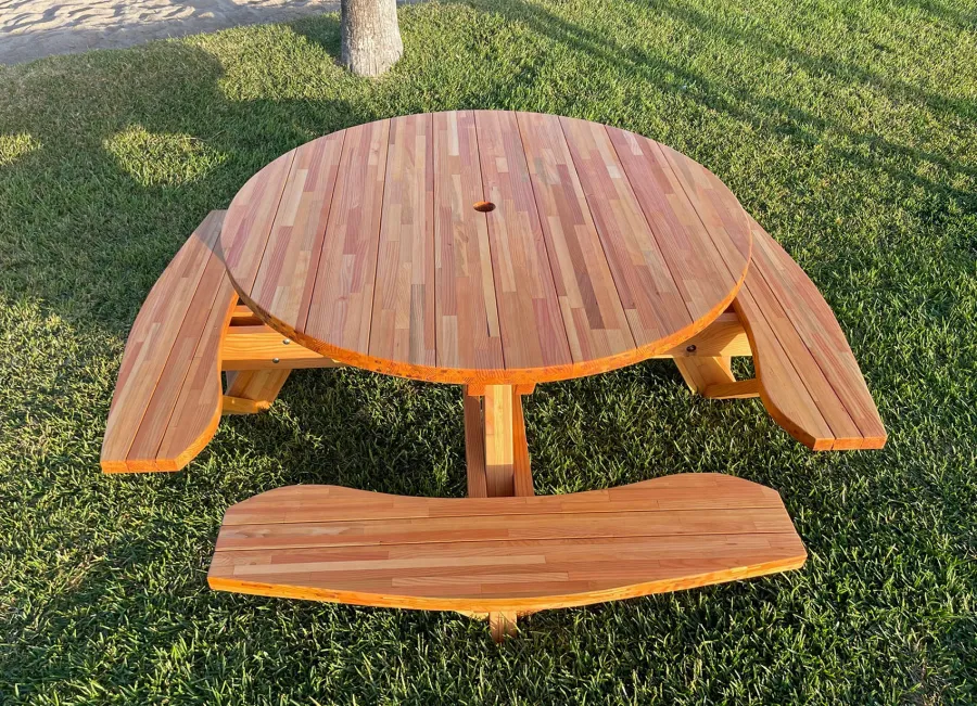 Round Wooden Picnic Table (Attached Benches) (Options: 5' Diameter, Attached Benches, Mosaic Douglas-Fir, Standard Tabletop, No Lazy Susan, 2" Umbrella Hole, Transparent Premium Sealant). Photo courtesy of El Estero Beach Resort in Ensenada, Mexico.