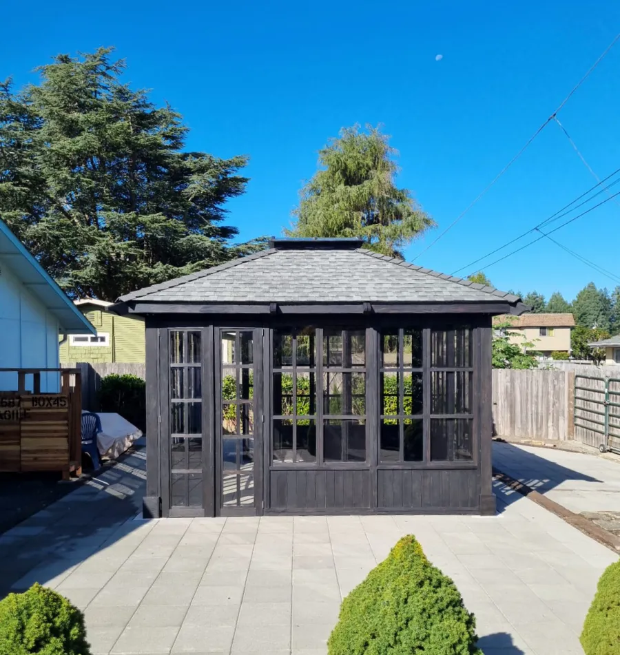 Spa Gazebo Kit (Options: 14' L, 14' W, Douglas-Fir, All Sliding Windows with Screens, 4' x 4' Skylight, 24" H Siding Below Windows, Vertical Siding, French Doors Without Screen, No Flooring, Black Stain Premium Sealant). Photo Courtesy of S. Mortensen of Eureka, CA.