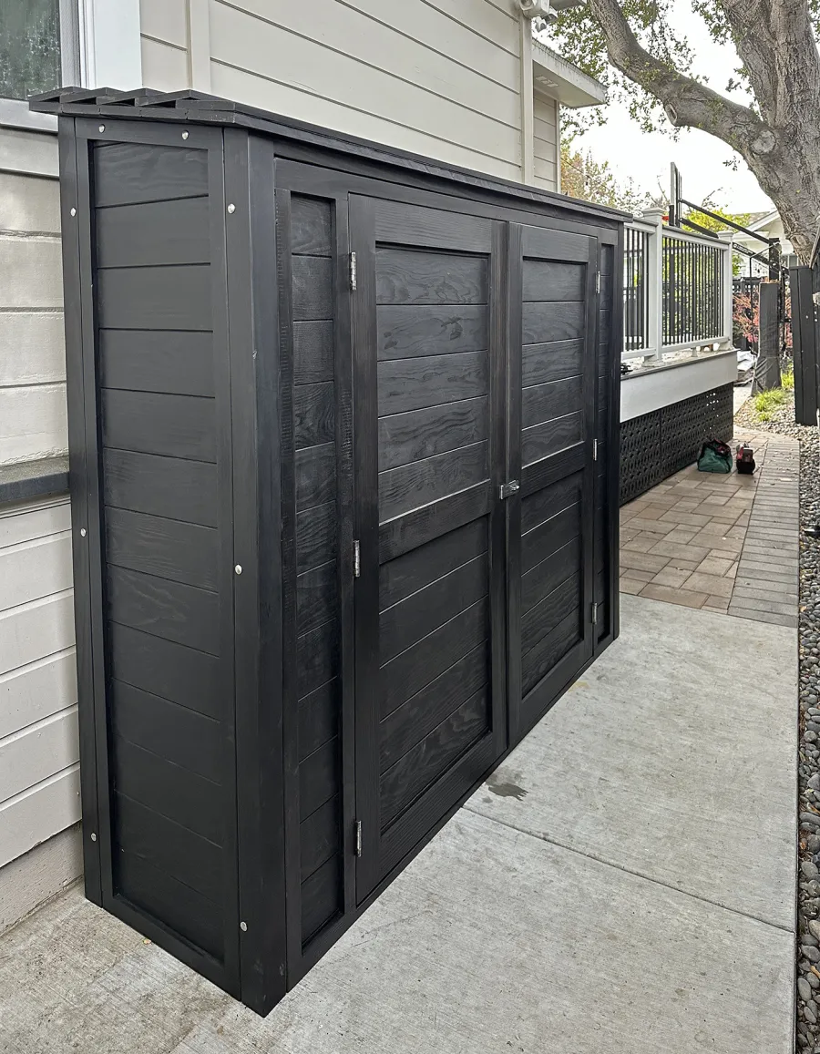 Storage Shed (Options: 7' W x 2' D x 6' H, Douglas-fir, Two Shelves, Inclination of the Roof to Be From Back to Door, Double Doors Opening Out From Center, Black Stain Premium Sealant). Photo Courtesy of L. Rutherford of Los Gatos, CA.