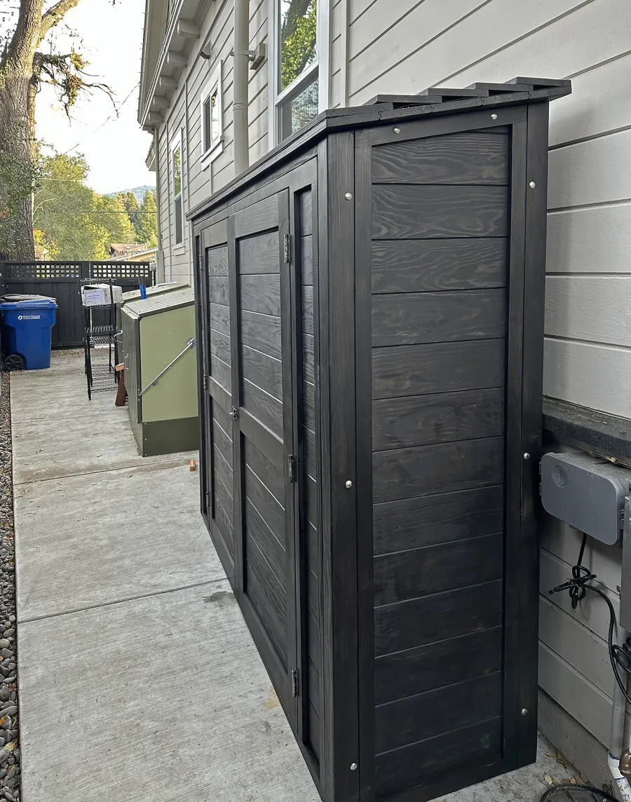 Storage Shed (Options: 7' W x 2' D x 6' H, Douglas-fir, Two Shelves, Inclination of the Roof to Be From Back to Door, Double Doors Opening Out From Center, Black Stain Premium Sealant). Photo Courtesy of L. Rutherford of Los Gatos, CA.