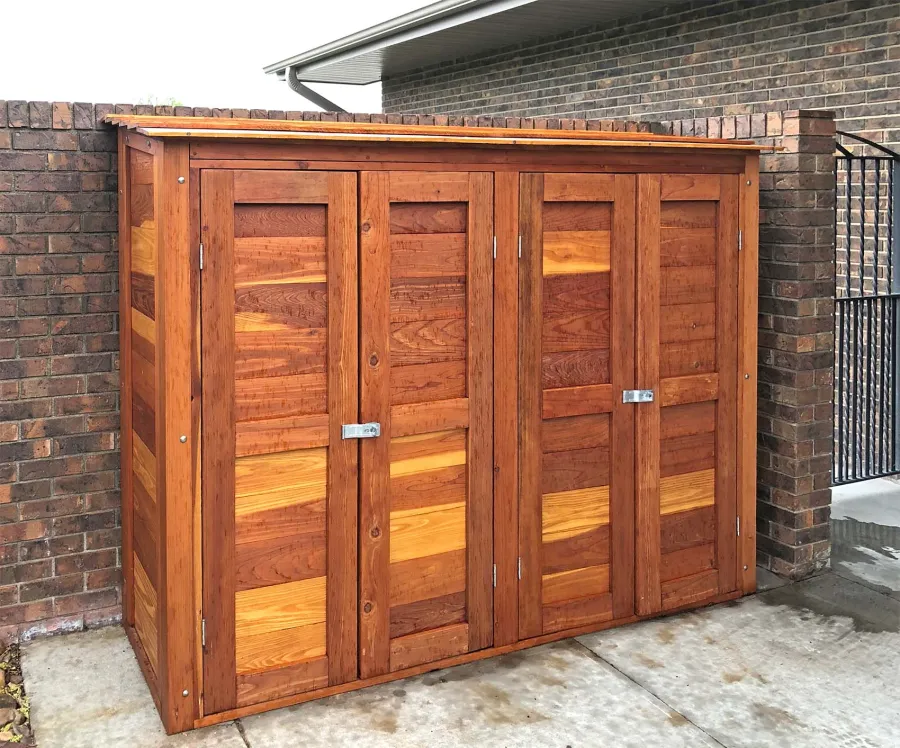 Storage Shed (Options: 8' W, 2' D, 5' H, California Redwood, Double Doors Opening Out From Center, Three Shelves at 18" H, 36" H and 50" H, Hardware Kit for Wood, Transparent Premium Sealant). Photo Taken When Rain Started. Photo Courtesy of J. Foster of Great Bend, Kansas.