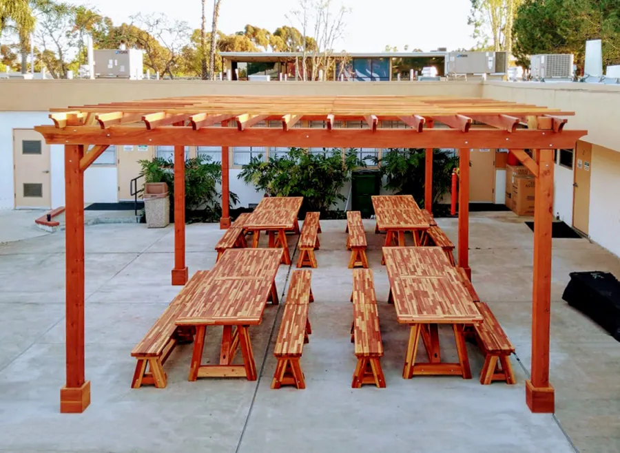 Classic Redwood Patio Table (Options: 10' L x 36" W, Mosaic Redwood, Side Benches, 2 Half Length Benches Per Side, Old Country Tabletop, Standard, Slightly Rounded Corners, No Umbrella Hole, Transparent Premium Sealant). Photo Also Shows a Garden Pergola. Photo Courtesy of T. Sirvent. Tables Installed in Vanguard University, Costa Mesa, CA.