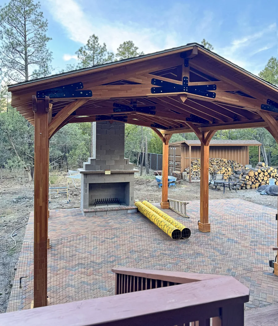 Esther Scissor Truss Pavilion (Options: 22’ L x 18’ W, Mosaic Douglas-Fir, Standard 3/4" T&G Roof Boards, 9.5' H Posts, No Ceiling Fan Base, 6 High-Wind Post Anchors, Cutout to fit Chimney on the Back, Transparent Premium Sealant). Photo Courtesy of H. O'Riley of Lakeside, AZ.
