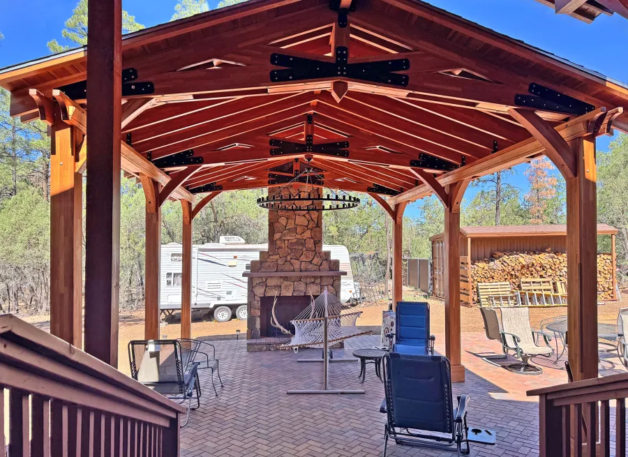 Esther Scissor Truss Pavilion (Options: 22’ L x 18’ W, Mosaic Douglas-Fir, Standard 3/4" T&G Roof Boards, 9.5' H Posts, No Ceiling Fan Base, 6 High-Wind Post Anchors, Cutout to fit Chimney on the Back, Transparent Premium Sealant). Photo Courtesy of H. O'Riley of Lakeside, AZ.