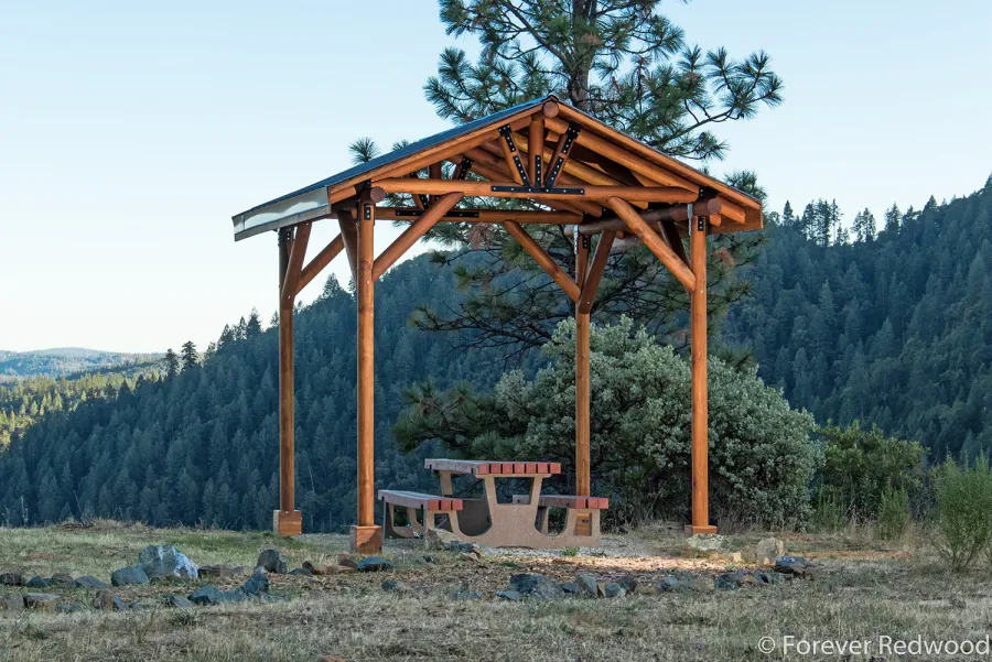 Humboldt Log Pavilion (Options: 6in x 6in Posts Thickness, 12ft L x 12ft W, No Privacy Panels, California Redwood, 2 Fascia Boards for Gutters, 9.5ft Post Height, No Electrical Wiring Trim, 4-Post Anchor Kit for High-Wind, No Ceiling Fan Fan Bases, No Curtain Rods, Transparent Premium Sealant). Metal Roof Installed by Custom Request.