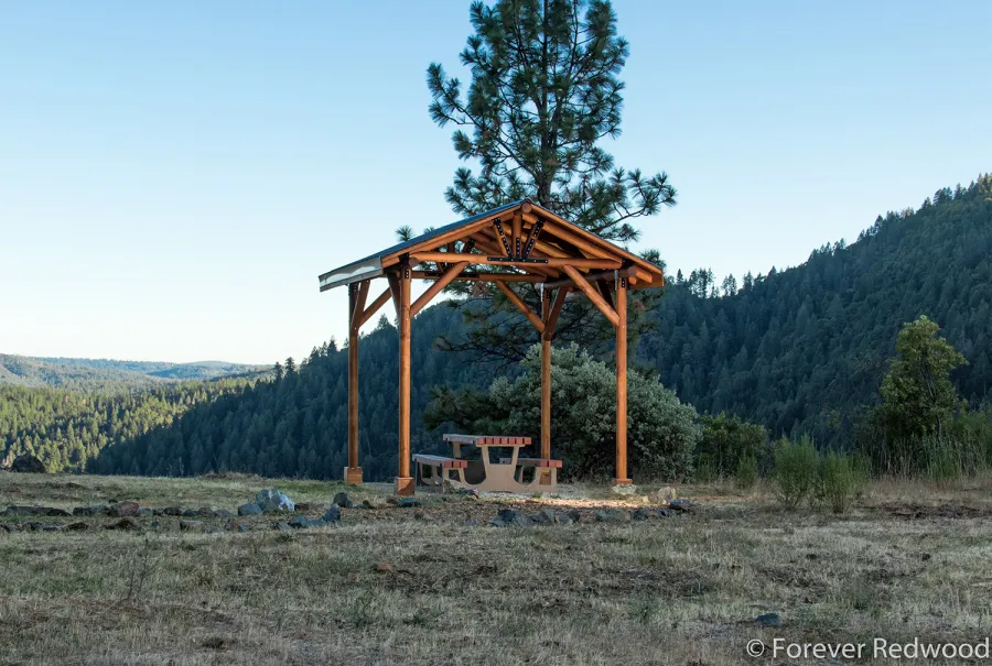 Humboldt Log Pavilion (Options: 6in x 6in Posts Thickness, 12ft L x 12ft W, No Privacy Panels, California Redwood, 2 Fascia Boards for Gutters, 9.5ft Post Height, No Electrical Wiring Trim, 4-Post Anchor Kit for High-Wind, No Ceiling Fan Fan Bases, No Curtain Rods, Transparent Premium Sealant). Metal Roof Installed by Custom Request.