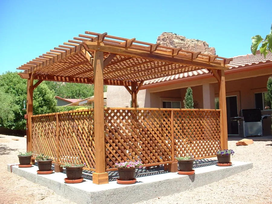 Lattice Pergola Kit (Options: 15' x 15', California Redwood, No Electrical Wiring Trim, 4-post Anchor Kit for Concrete, No Ceiling Fan Base, 2 Privacy Panels, No Curtain Rods, 9' Post Height, Transparent Premium Sealant). 2x2 Slats Above Rafters was Added as Custom Detail. It is not Part of Standard Design. Under the Pergola, a 7' San Francisco Patio Table Set with 42" W Tabletop, 4 Ruth Chairs and 2 Ruth Armchairs. Photo Courtesy of Mr. Joseph Dlugosz of Sedona, AZ.