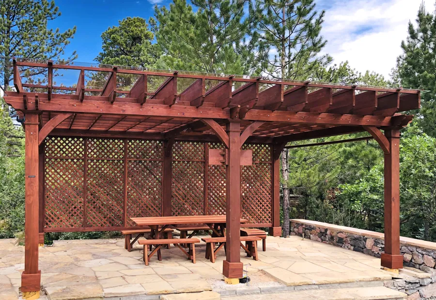 Montvale Pergolas (Options: 24' x 16', Mature Redwood, 6-Post Anchor Kit for Concrete, 1 Ceiling Fan Base and 1 T.V. Base, 2 Curtain Rods, 1 Lattice Privacy Panel, 9.5' H Posts, with Rain Guard, Coffee-Stain Premium Sealant). A Forever Picnic Table Set with Unattached Benches Shown Under the Pergola. Photo Courtesy of J. Brinkman of Castle Rock, Colorado.