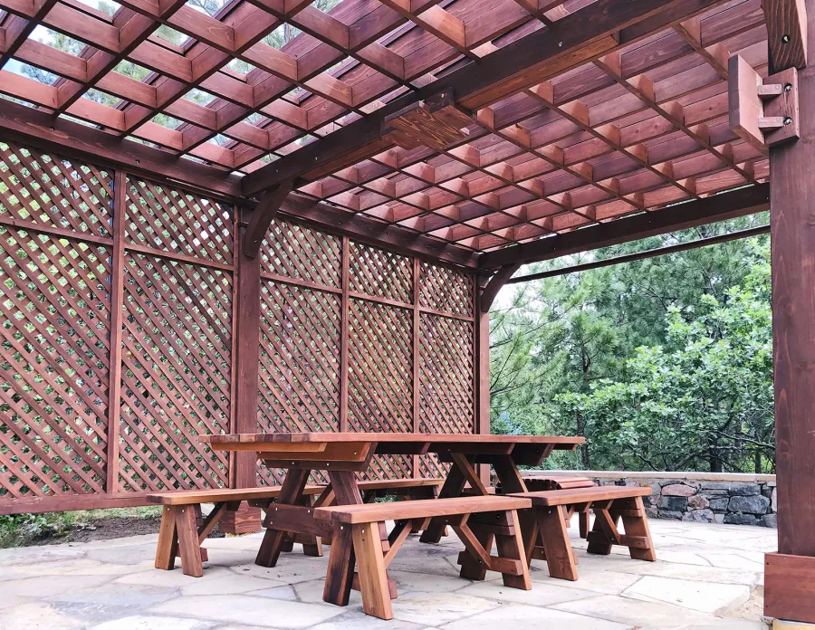 Montvale Pergolas (Options: 24' x 16', Mature Redwood, 6-Post Anchor Kit for Concrete, 1 Ceiling Fan Base and 1 T.V. Base, 2 Curtain Rods, 1 Lattice Privacy Panel, 9.5' H Posts, with Rain Guard, Coffee-Stain Premium Sealant). A Forever Picnic Table Set with Unattached Benches Shown Under the Pergola. Photo Courtesy of J. Brinkman of Castle Rock, Colorado.