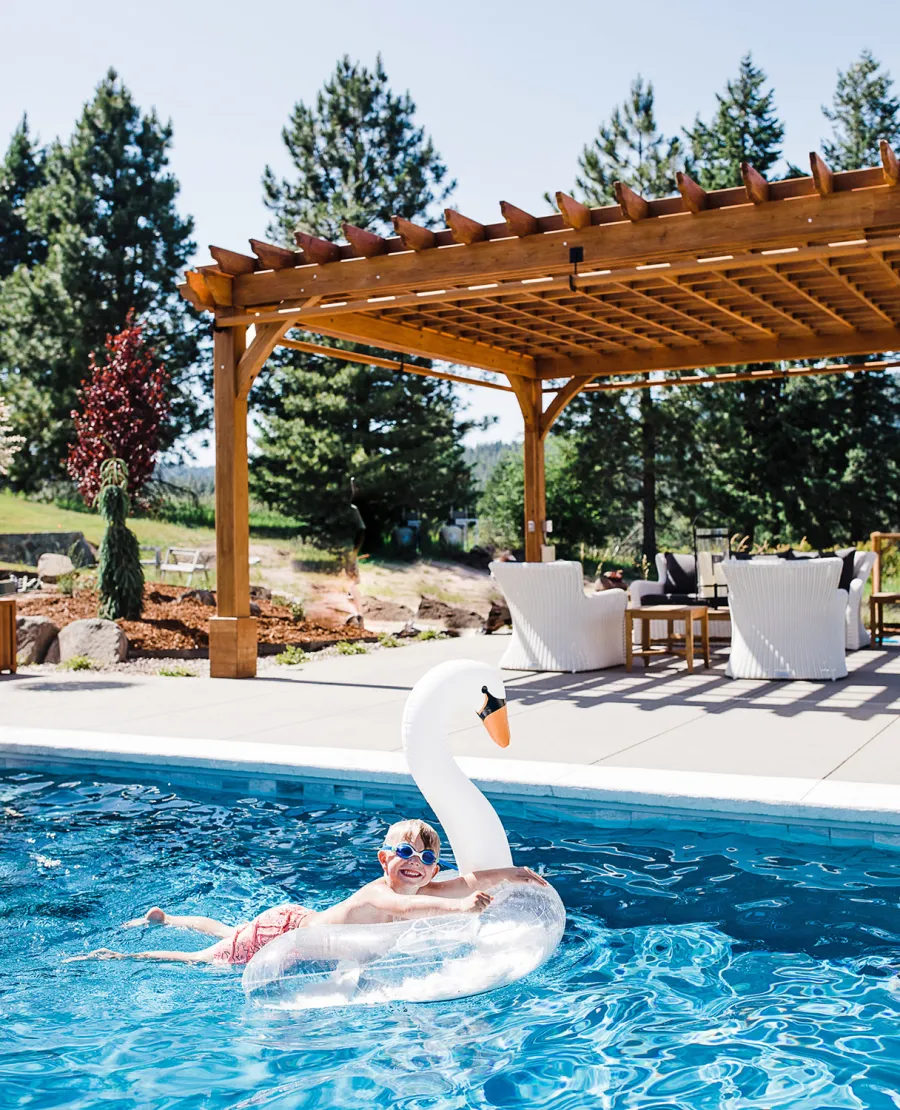 Montvale Pergolas  (Options: 22' x 22', Mature Redwood, 4-Post Anchor Kit for Concrete, Electrical Wiring Trim Kit for 4 Posts, No Ceiling Fan Base, 4 Curtain Rods, No Privacy Panels, 10' Post, Transparent Premium Sealant). Photo Courtesy of J. Scott of Coeur deline, Idaho.