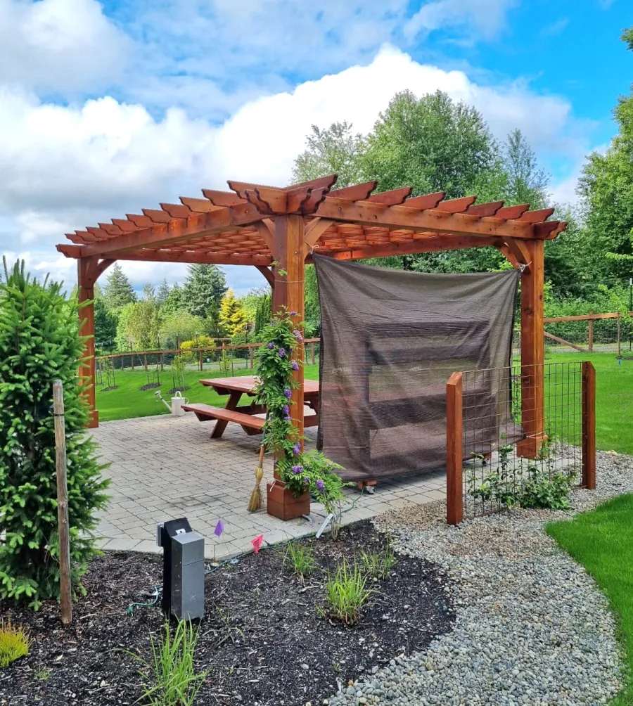 Montvale Pergola (Options: 20' x 14', Mature Redwood, 4-Post Anchor Kit for Concrete, No Ceiling Fan Base, No Curtain Rods, No Privacy Panels, 9' H Posts, Transparent Premium Sealant). Photo Also Shows a Forever Picnic Table. Photo Courtesy of R. Greenfield of Gig Harbor, Washington.